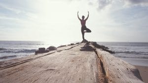 Woman posed for yoga at end of dock Financial Strategies Group blog